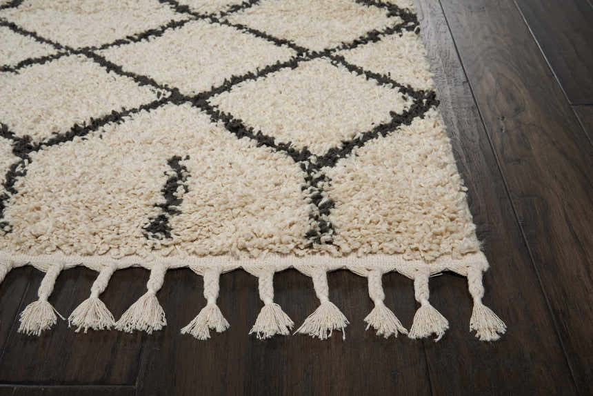 Close-up of Nourison Moroccan Shag Cream Tribal rug, showing diamond pattern, shaggy texture and tassel fringe detail.