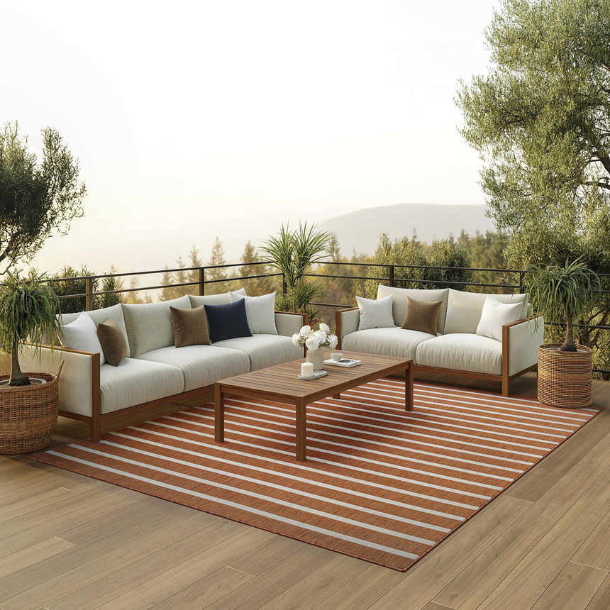 Outdoor living space with modern sofas and Nourison Positano Terracotta Ivory rug featuring a striped pattern.