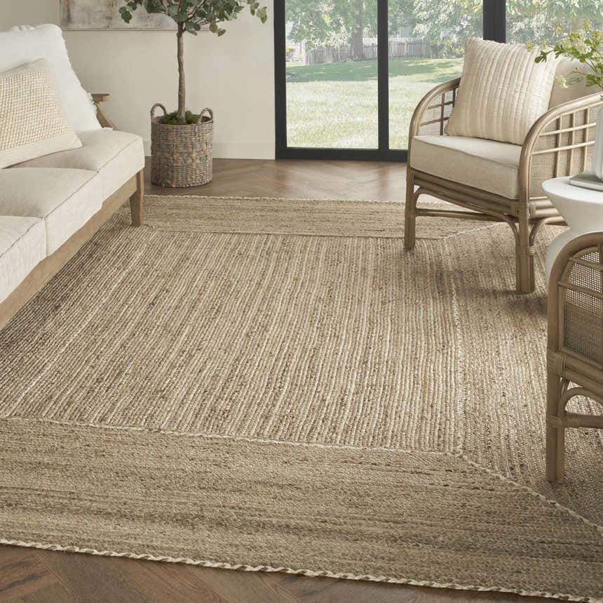 Farmhouse living room with a Nourison Terrazzo Jute Natural Grey rug, sofa, and rattan chairs.