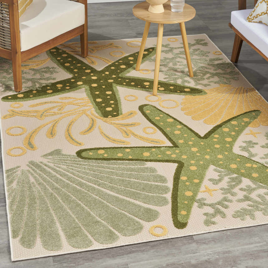 Outdoor patio scene with Nourison Aloha Green Yellow rug featuring starfish and shell design.