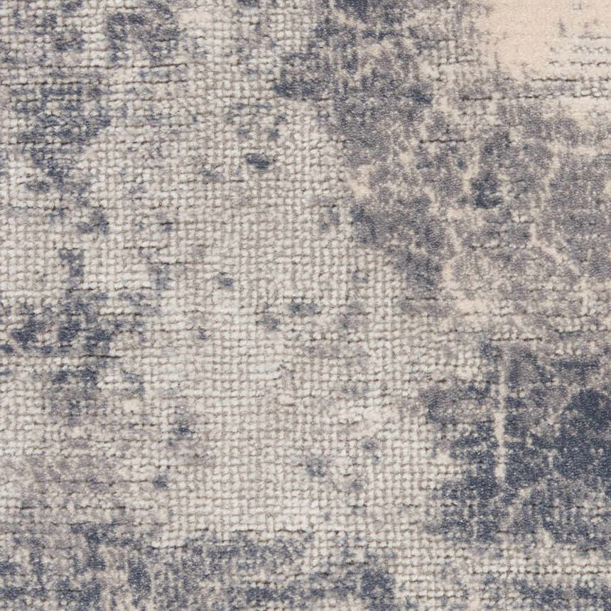 Close-up of the Nourison Rustic Textures Blue Ivory rug, showing the textured weave and abstract chestnut pattern.