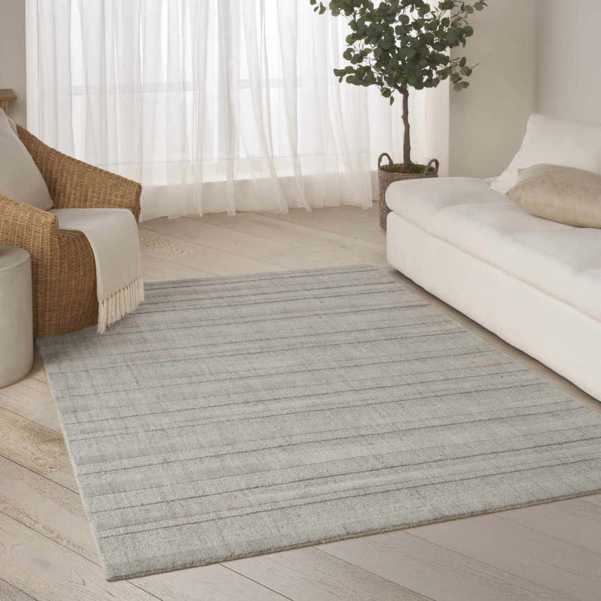 Living room with a DKNY Pure Multi Weave Grey Contemporary Indoor Area Rug, white sofa, and woven chair.