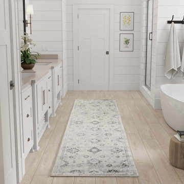 Bright bathroom scene with the Nourison Astra Ivory Vintage Washable Area Rug runner on light wood floor.