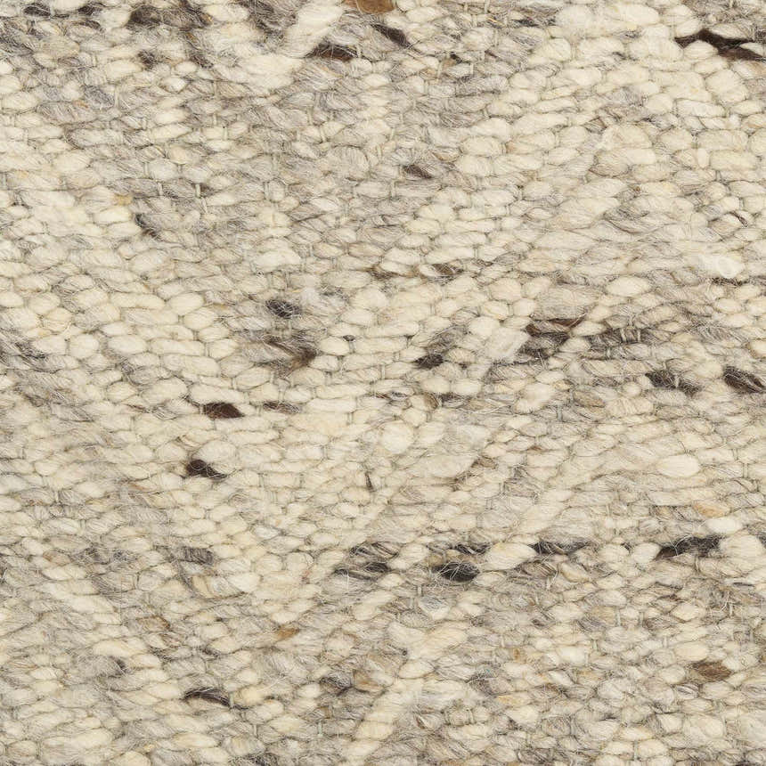 Close-up of the DKNY Pure Purl rug showing its ivory and grey tones, textured wool weave, and chestnut flecks.