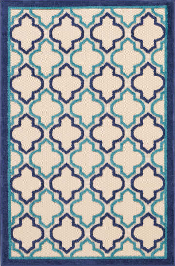 Close-up of Nourison Aloha Navy Outdoor Area Rug featuring a quatrefoil pattern in navy and turquoise on a beige background.