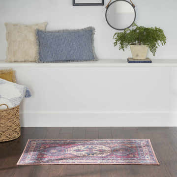 Hallway scene with Nourison New Concept Red Navy Vintage rug on dark wood floor. Pillows and plant on shelf.