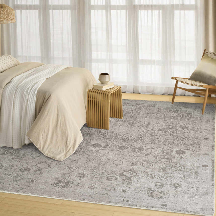 Neutral bedroom scene with a grey vintage DKNY Pure Shades area rug, wood floors, and sheer curtains.