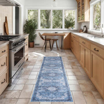 Light blue Nourison Vintage rug in a bright kitchen with wood cabinets and tile floor.