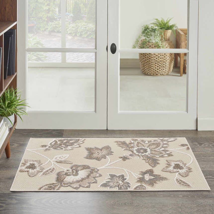 Entryway with Nourison Aloha Beige Farmhouse Area Rug featuring a floral pattern on dark wood floors.