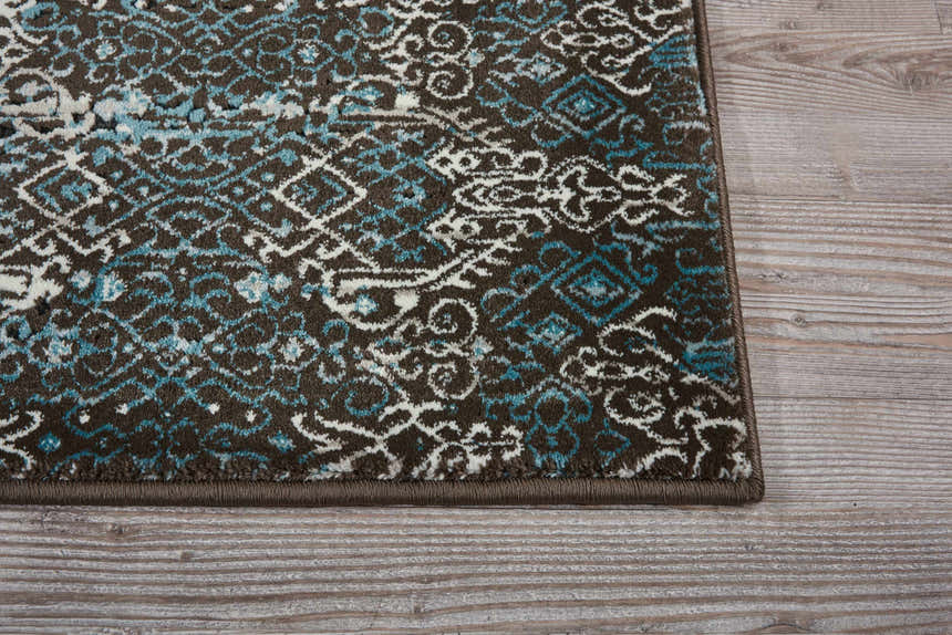 Close-up of Nourison Karma Blue Vintage rug. Features light blue, white, and brown vintage-style pattern.