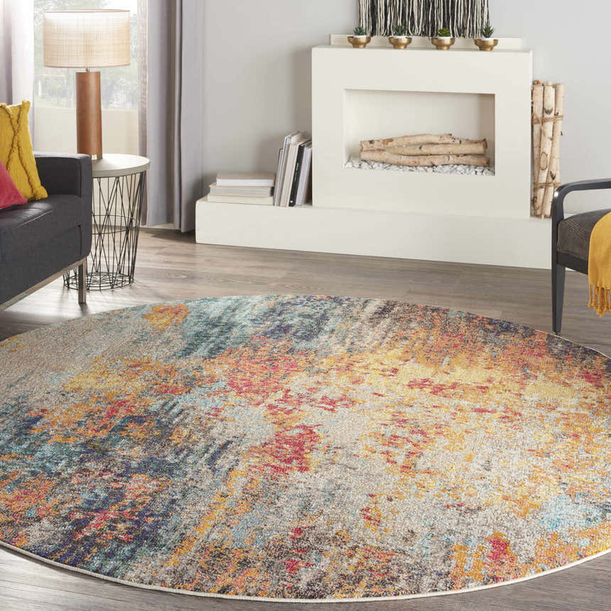 Living room scene with a round Nourison Celestial Multicolor area rug, gray sofa, and fireplace.