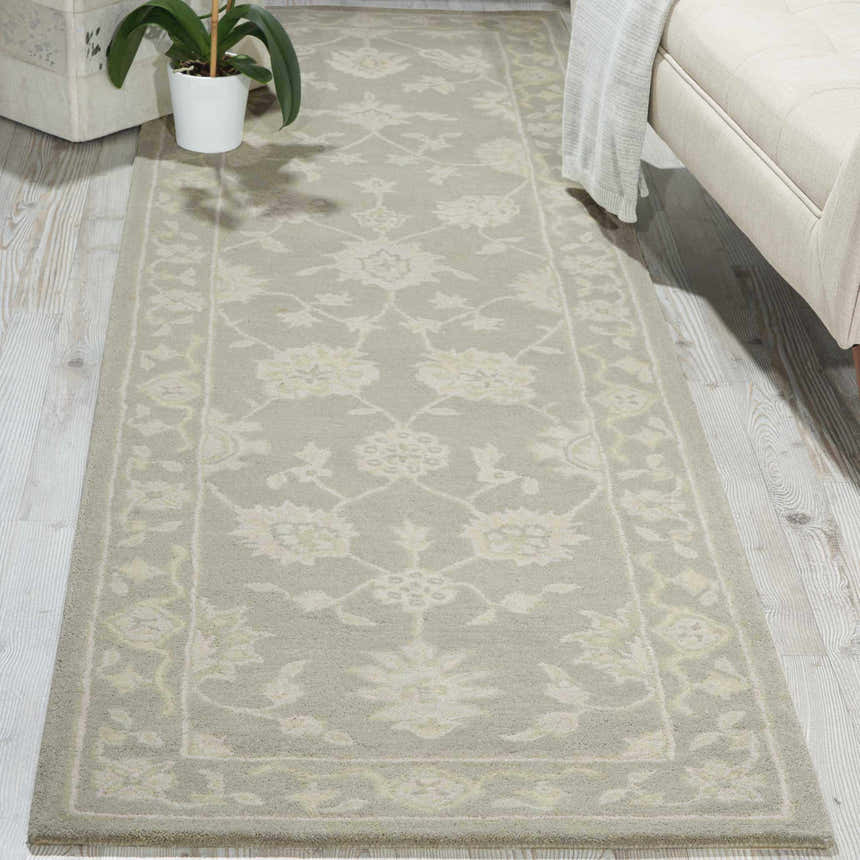 Living room scene with a light taupe Nourison Zephyr runner rug, ivory sofa, and potted plant on wood floors.