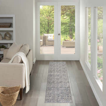 Hallway with Nourison Serenity Home Blue Ivory runner rug, light wood floors, leading to outdoor patio. Modern, bright.