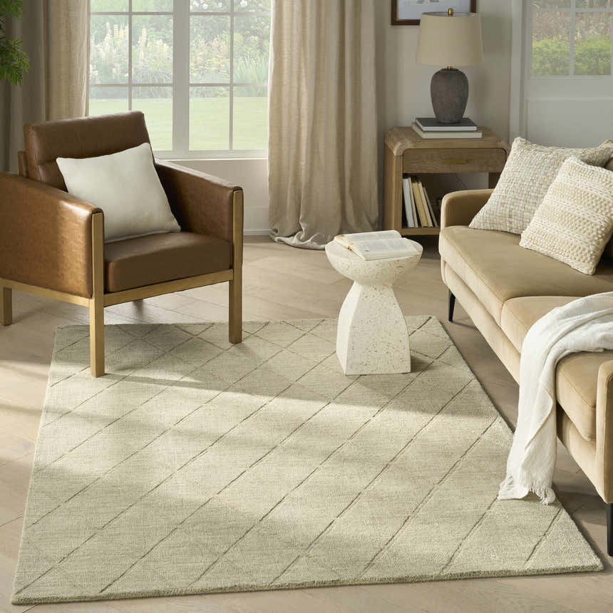 Living room scene with a Nourison Wool Haven Sage rug, tan sofa, leather chair, and natural light.
