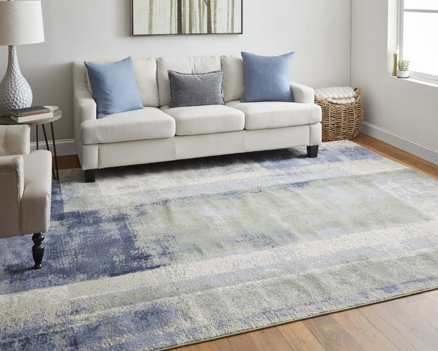 Living room scene with Feizy Clio blue, green, and ivory abstract rug, white sofa, and wood floors. Roomscene-Rectangle