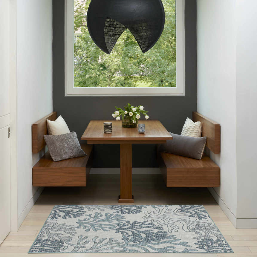Breakfast nook with wood benches and Nourison Garden Oasis Blue Coastal Area Rug.