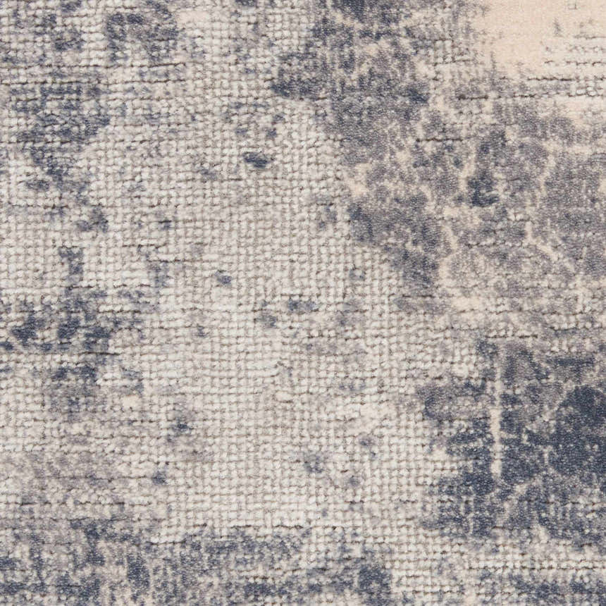 Close-up of the Nourison Rustic Textures Blue Ivory rug, showing its textured weave and abstract chestnut pattern.