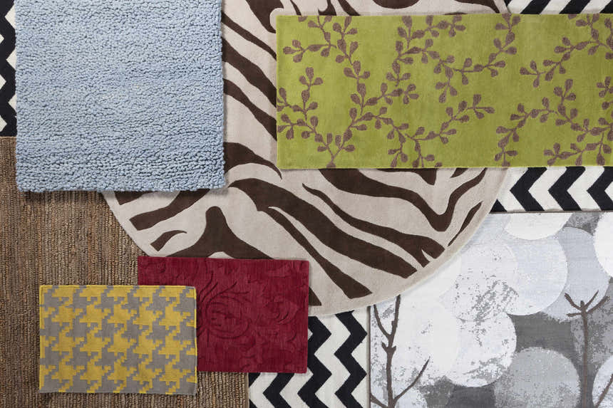 Close-up of rug samples: Greenbelt rug in ice blue, green vine, zebra, red floral, and yellow houndstooth patterns. Styleshot