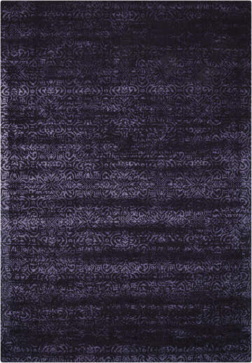 Close-up of the Calvin Klein Home Maya Nightshade rug. The rug features a dark purple, ornate, floral-inspired pattern.