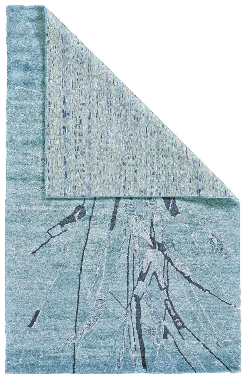 Close-up of the Feizy Cosmo rug; a blue, gray, and green transitional area rug with an abstract pattern. Fold