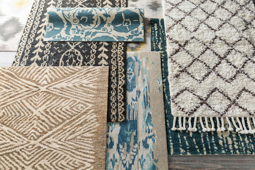 Overhead view of assorted rug textures and patterns, including Hendon Jute Clearance Rug in ivory and tan. Styleshot