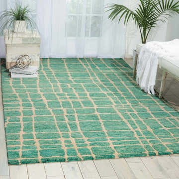 Living room scene with Nourison Tahoe Turquoise Green rug, white bench, and light wood floors.