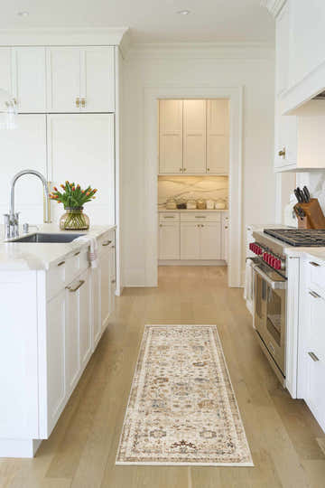 Bright white kitchen with Nourison Pardis Ivory Rust vintage runner rug on wood floor.