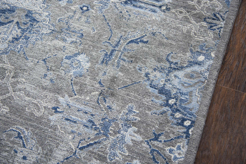 Close-up of the Rizzy GS7225 area rug. Features a blue and gray floral pattern on a soft, textured wool. Texture