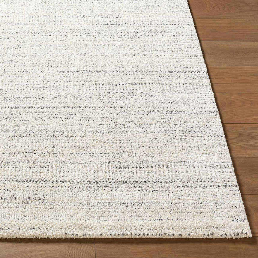 Close-up of the Sezja Beige Luxe Area Rug showing its textured, horizontal line pattern in beige, cream, and black. Front