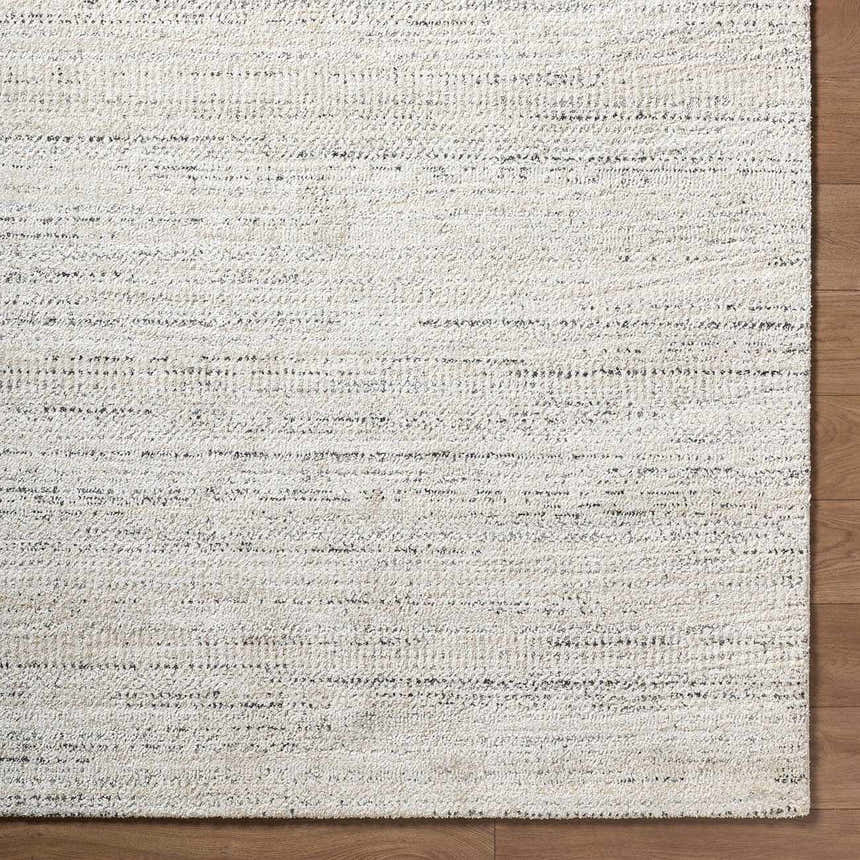 Close-up of the Sezja Beige Luxe Area Rug featuring a subtle horizontal line pattern in beige, cream, and black. Corner