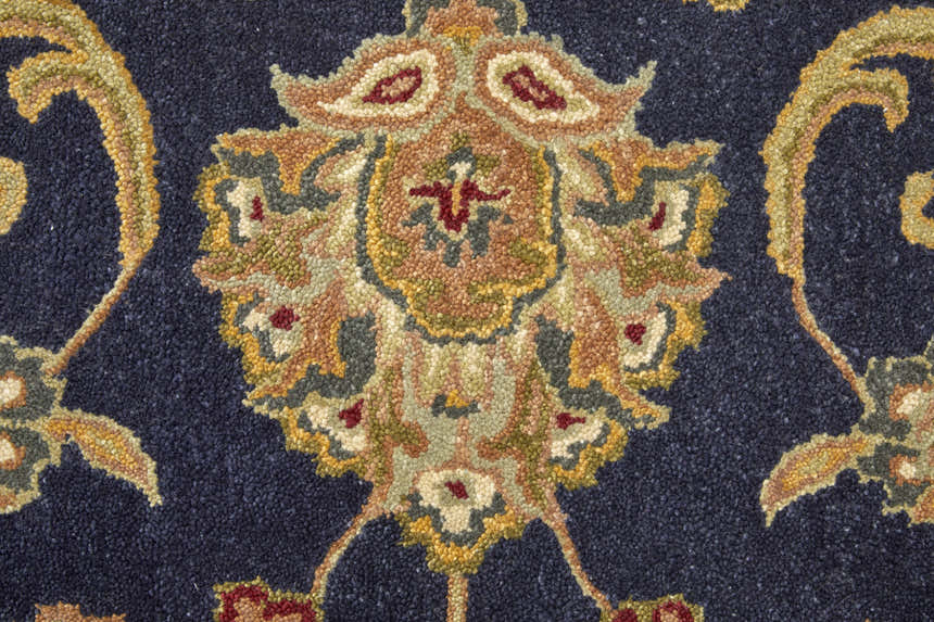 Close up of the Feizy Wagner rug showing its wool texture and traditional blue, tan, and gold floral design. Texture