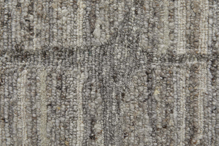 Close-up of the textured, hand-woven Feizy Navaro rug. Gray, ivory, and taupe wool and viscose fibers. Texture
