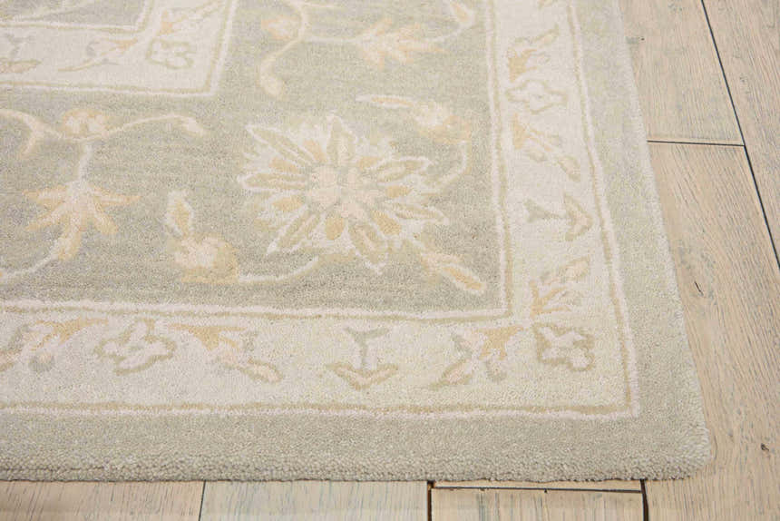 Close-up of the handmade Nourison Zephyr Silver area rug. Features a floral design in silver gray and cream tones. Wool texture.