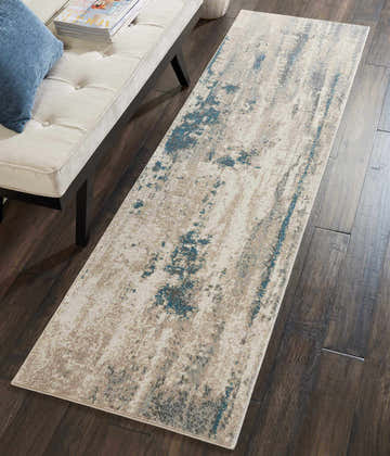 Modern living room scene with Nourison Maxell Ivory Teal rug, cream bench, blue pillow, and dark wood floors.