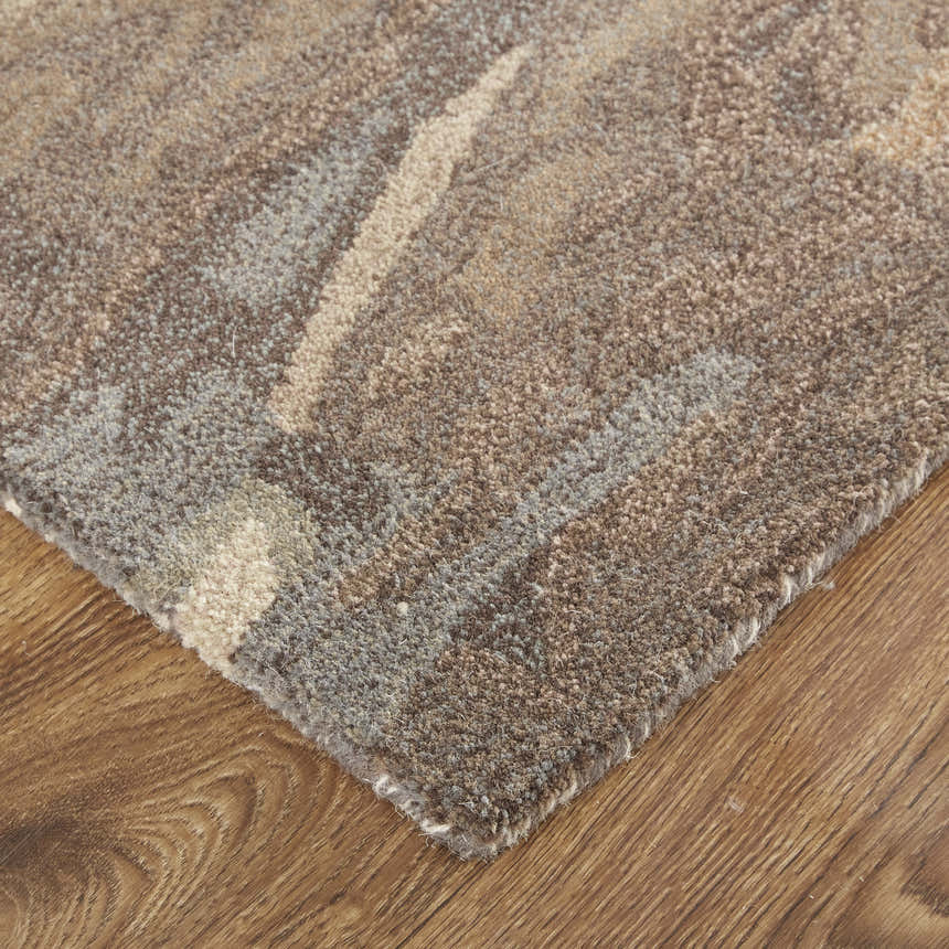 Close up of the Feizy Amira rug showing the abstract brown, gray, and tan pattern and textured wool fibers. Corner