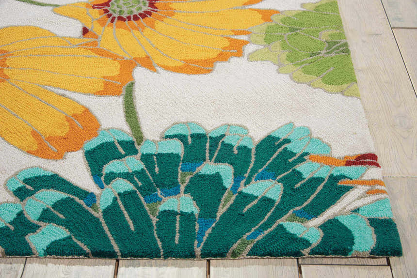 Close-up of the Nourison Fantasy Ivory rug showing floral pattern in yellow, green, and teal on a light background.