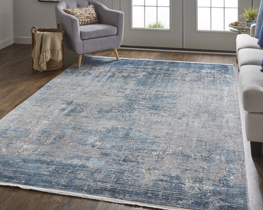 Living room scene with a Feizy Cadiz rug in blue, gray, and silver under a gray chair and light sofa. Roomscene-Rectangle