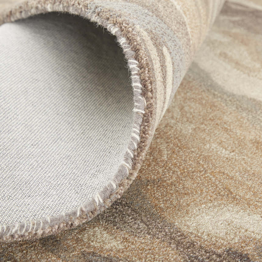 Close-up of the hand-tufted Feizy Amira rug showing the wool texture, cotton backing, and brown, gray, and tan abstract pattern. Fold