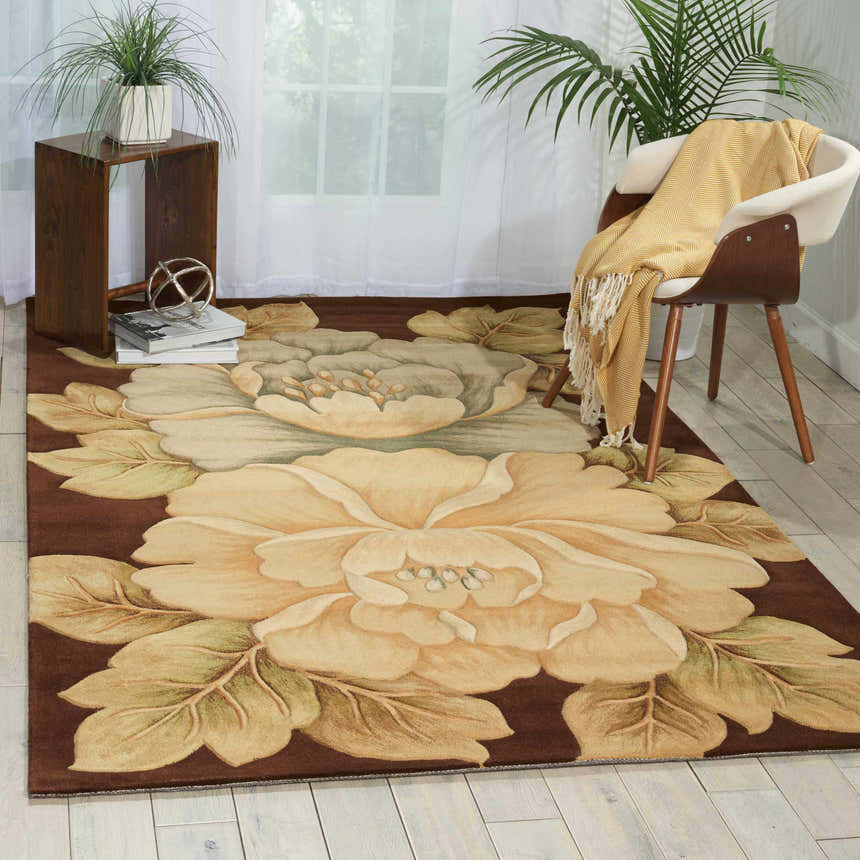 Living room scene with Nourison Tropics Brown contemporary rug. Features floral design, wood chair, side table, and light wood floors.