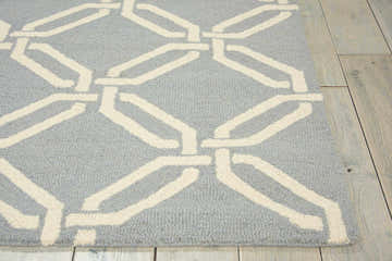 Close-up of Nourison Linear Light Blue rug showing geometric design and wool texture on wood floor.