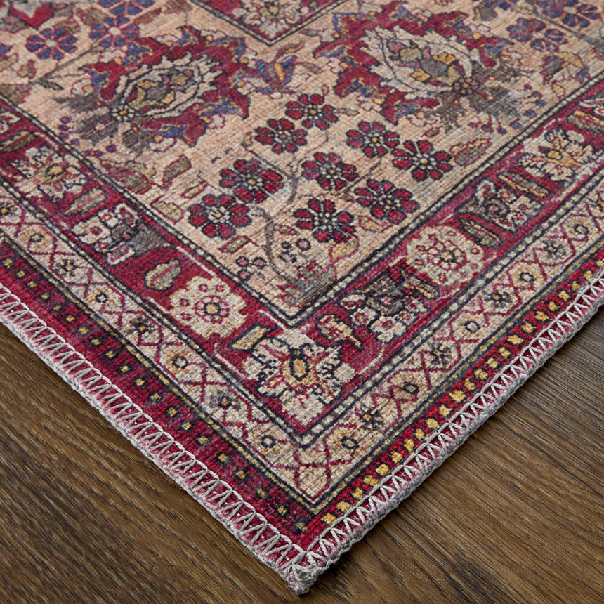 Close-up of Feizy Rawlins rug. Transitional oriental design in red, tan, and pink on a wood floor. Corner