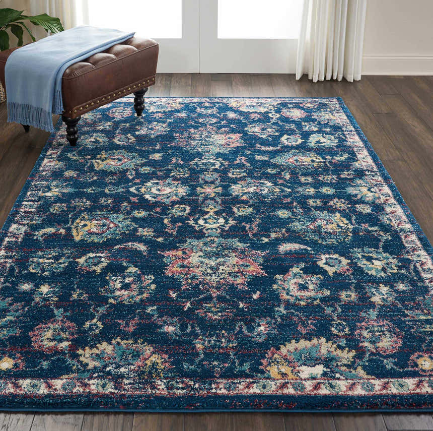 Living room scene with Nourison Fusion Navy Pink Persian rug, leather ottoman, and wood floors.