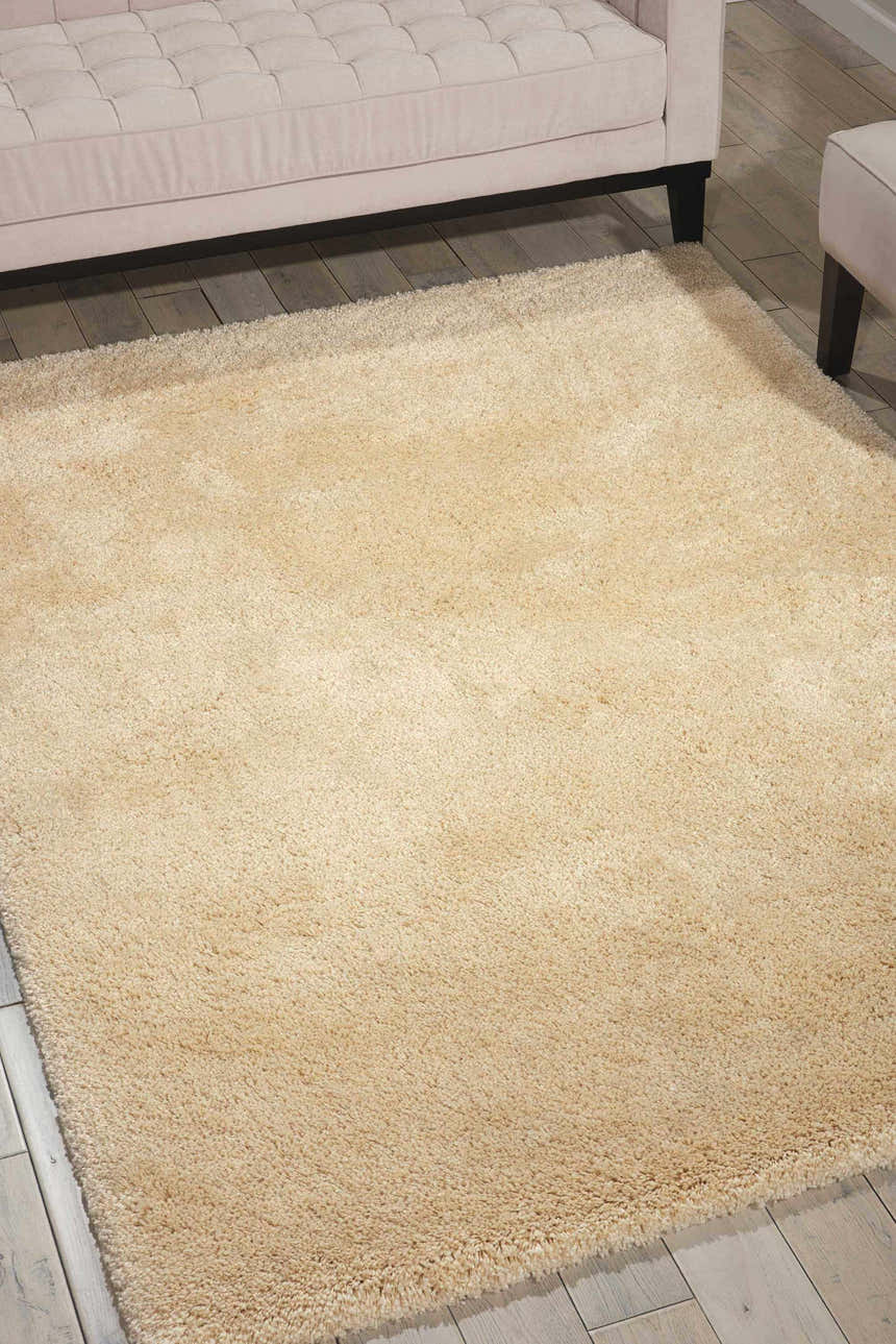 Living room scene with a beige Nourison Yummy Shag rug, light wood floors, and a neutral sofa.