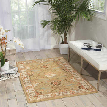 Sunlit room with Nourison India House Sage Farmhouse Rug, white bench, wood floors, and plants for a serene, organic feel.