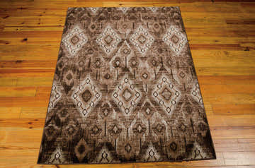 Close-up of the Nourison Karma Chocolate Vintage Area Rug, featuring a brown diamond pattern on a wooden floor.