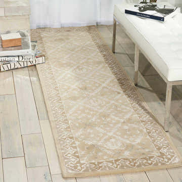 Entryway with a Nourison Symphony Sand runner rug, light wood floors, and a white bench.
