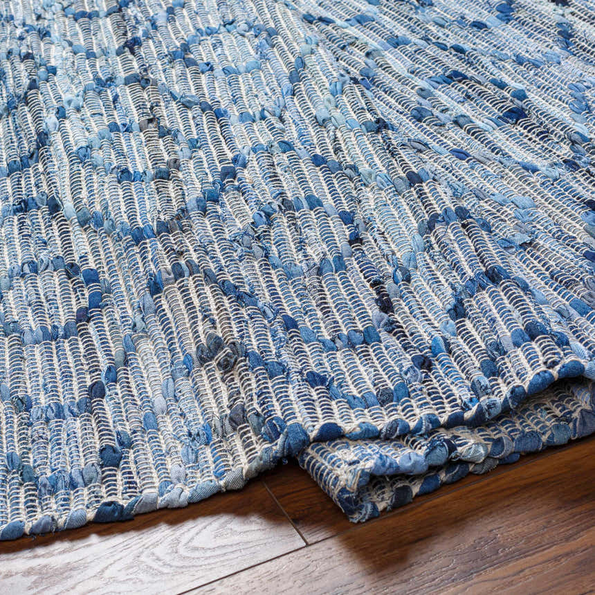Close-up of the hand woven Gurit Blue & Brown Area Rug, a contemporary rug made of recycled fabric. Fold