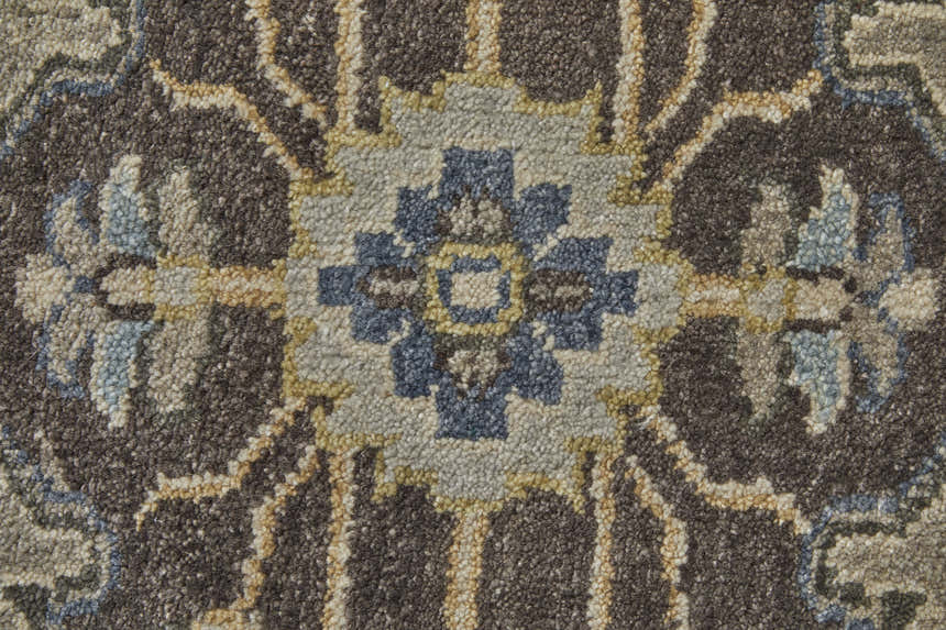 Close-up of the Feizy Ustad rug. Traditional Persian design in gray, taupe, and blue wool with a floral medallion pattern. Texture