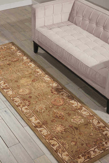 Living room scene with a light pink sofa and Nourison 3000 Light Green Persian rug on light wood floors.