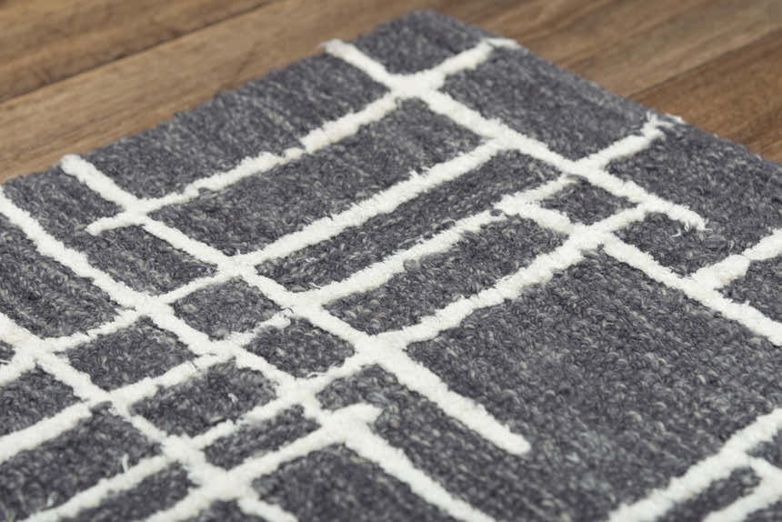 Close-up of Rizzy JZZ971 area rug. Gray wool rug with a raised ivory geometric pattern and textured pile. Texture